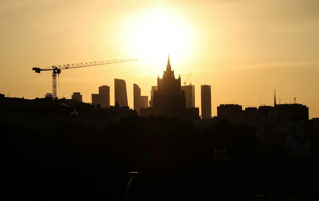 Силуэт Москвы на закате: сталинская высотка, башни Сити и башенный кран